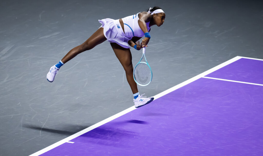 Coco Gauff hitting a serve against Jasmine Paolini at the 2025 WTA Finals.