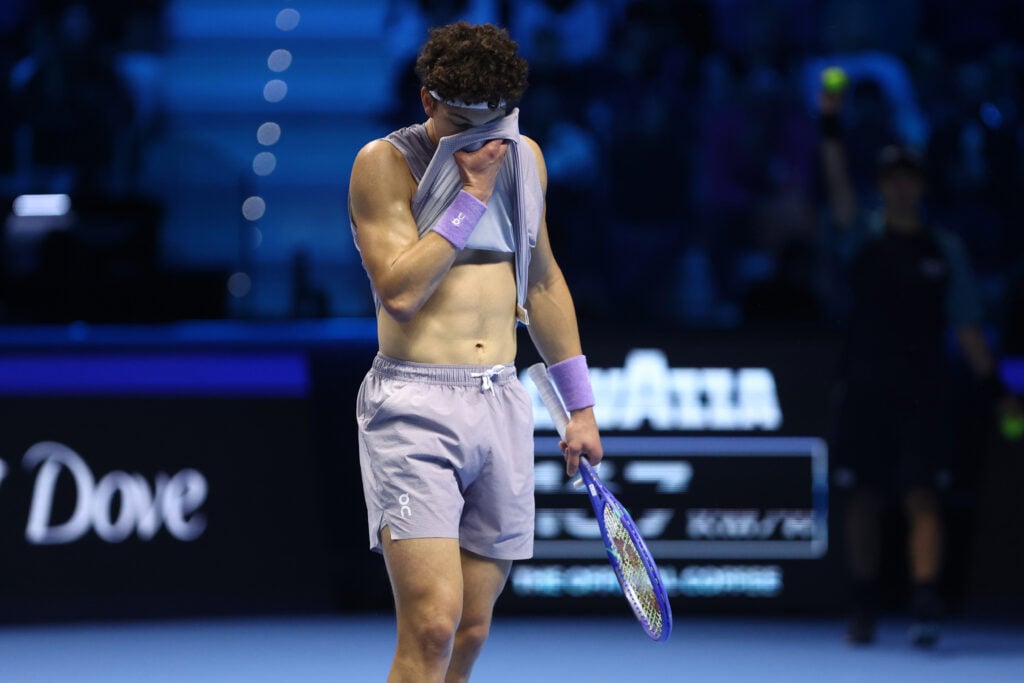 Ben Shelton covers his face with his t-shirt after losing a point against Alexander Zverev at the 2025 ATP Finals in Turin.