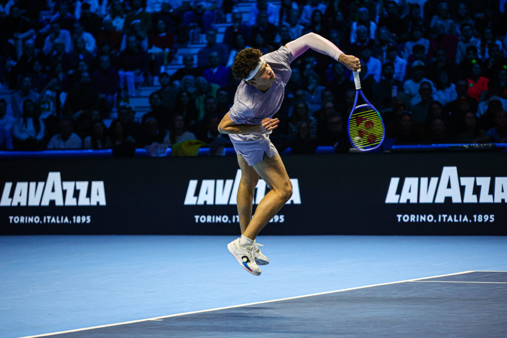 Ben Shelton hits a serve against Jannik Sinner at the 2025 ATP Finals in Turin.