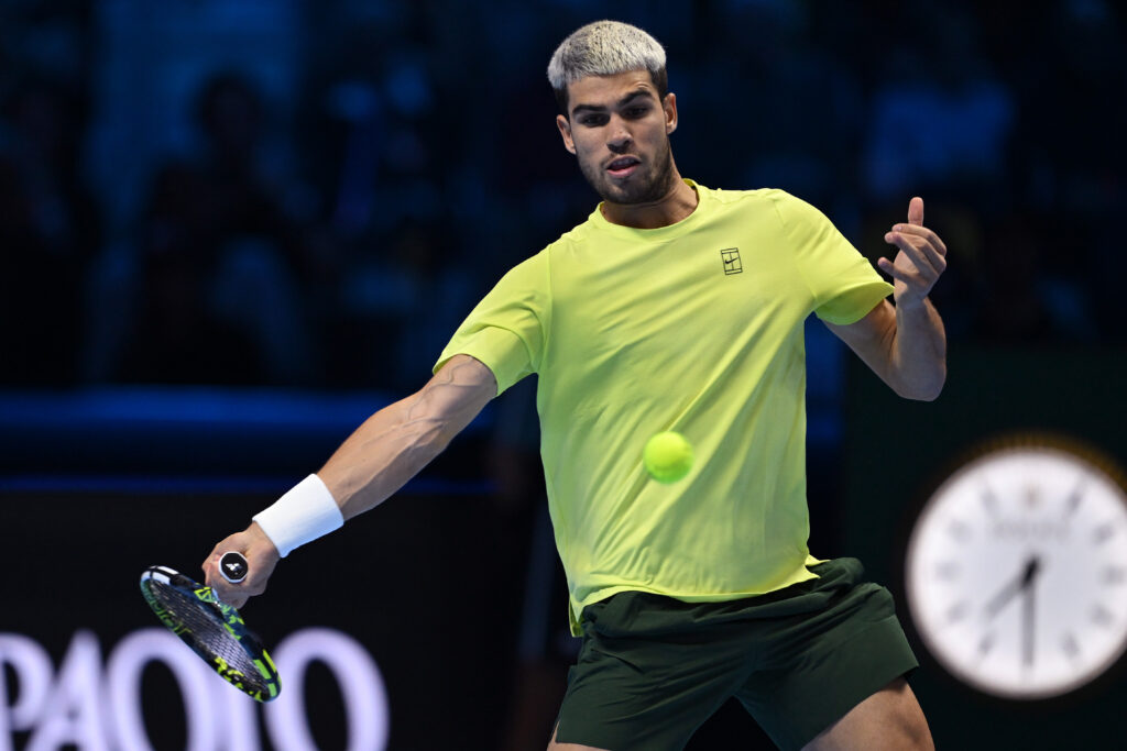 Carlos Alcaraz plays a forehand against Jannik Sinner at the 2025 ATP Finals in Turin.