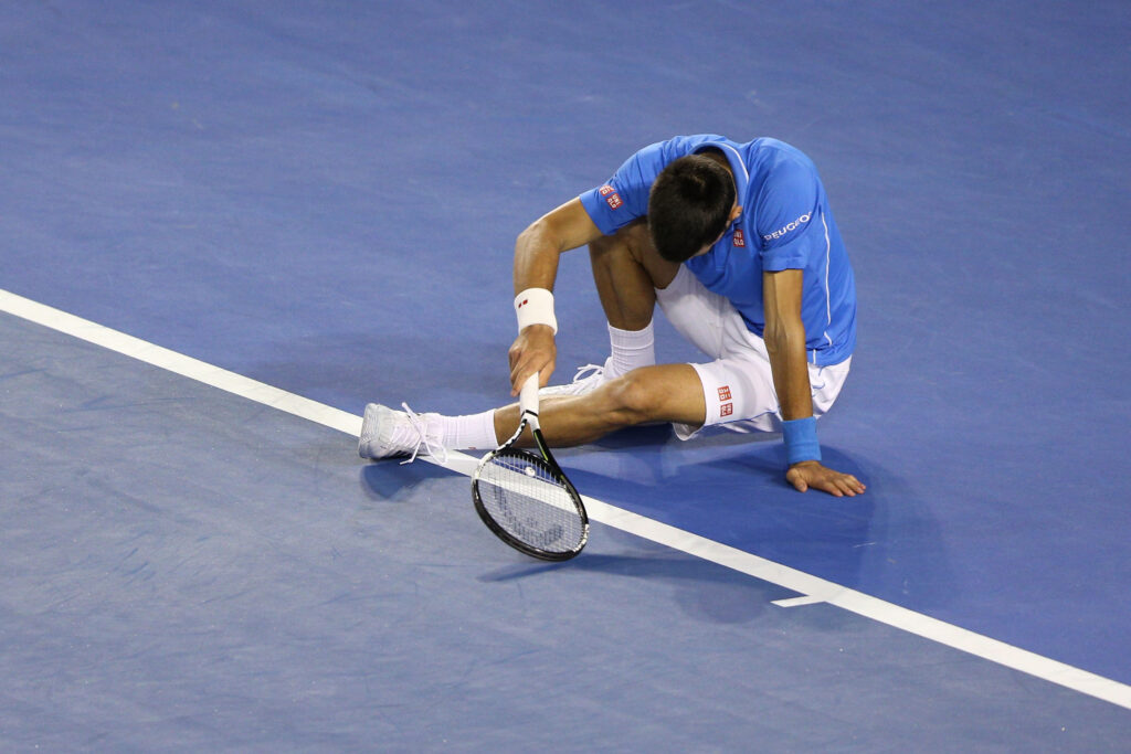 Novak Djokovic falls to the floor during the 2015 Australian Open final