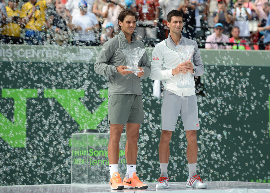 Rafael Nadal and Novak Djokovic hold their trophies after the 2014 Miami Open final.