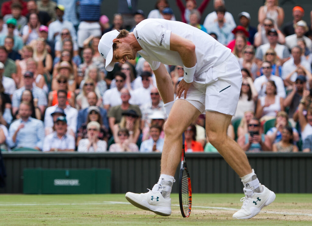 Andy Murray holding his hip during a match at Wimbledon in 2017.