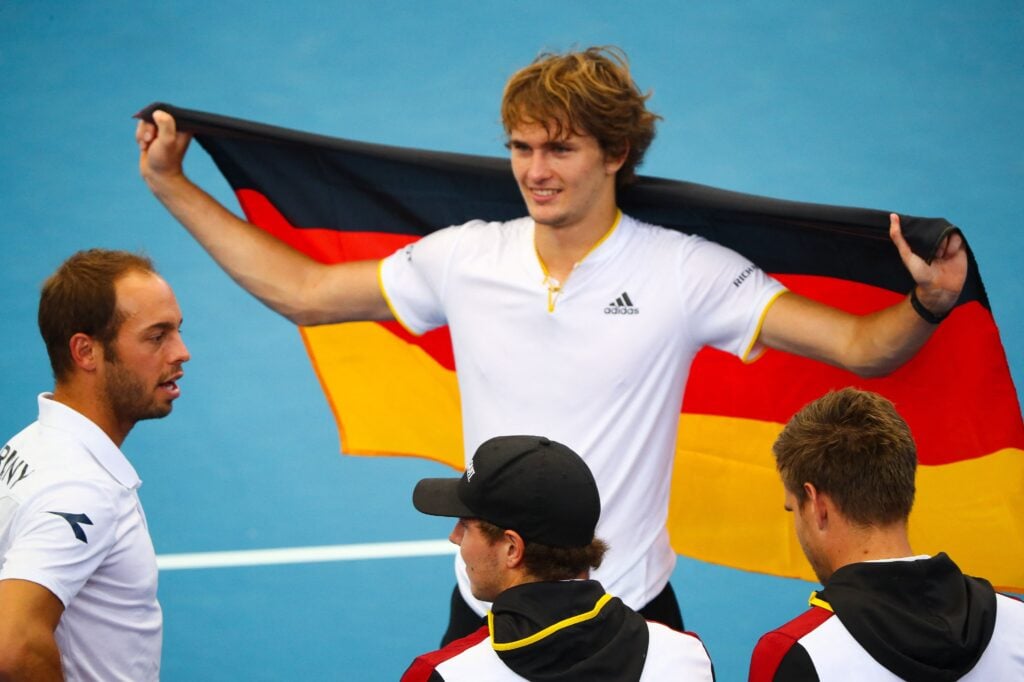 Alexander Zverev holds up the German flag at the Davis Cup in 2018