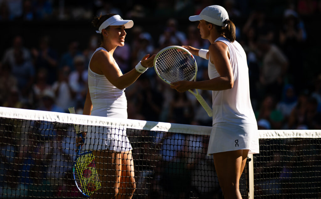 Belinda Bencic and Iga Swiatek embrace after their semifinal match at Wimbledon in 2025