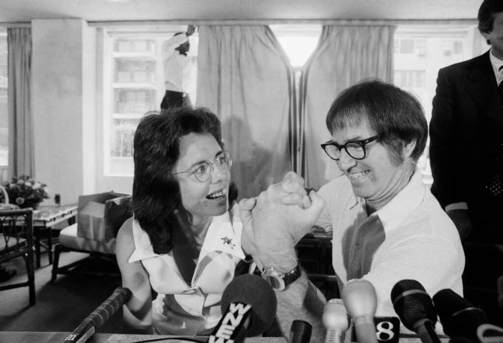 Former tennis great Bobby Riggs and top female tennis player Billie Jean King arm wrestle at a press conference, where they announced they'll face each other in a 0,000 winner-take-all tennis match. Billy Jean went on to defeat Riggs, 6-4, 6-3, 6-3.