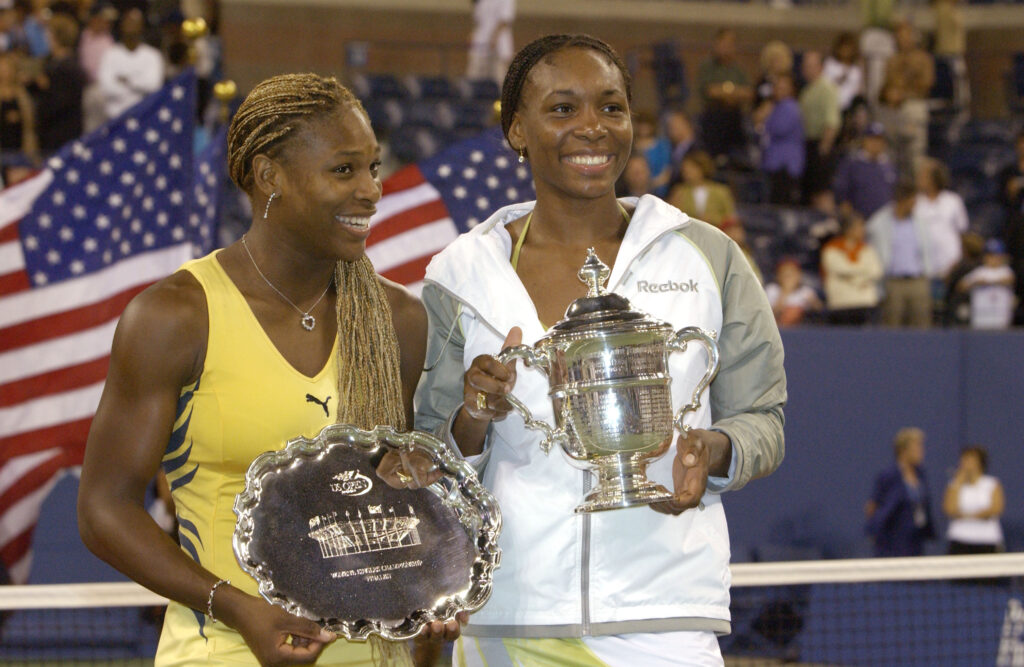 Serena Williams and Venus Williams pose with their trophies after the 2001 US Open final