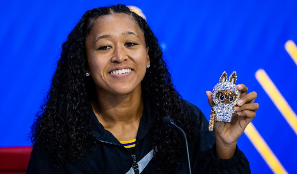 Naomi Osaka holds up a Labubu during a press conference at the 2025 US Open