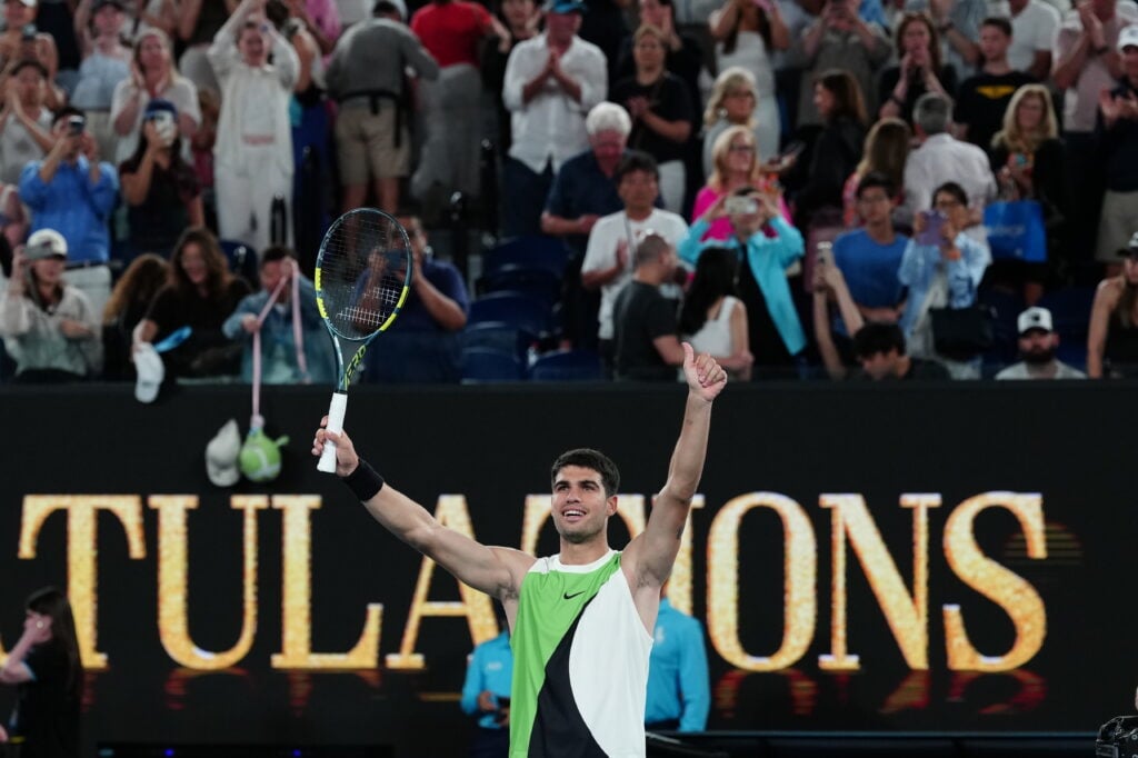 Carlos Alcaraz raises his arms in celebration