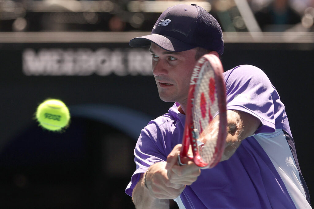 Tommy Paul hits a backhand against Carlos Alcaraz at the 2026 Australian Open.