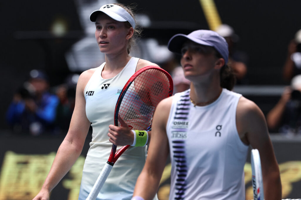 Iga Swiatek walks alongside Elena Rybakina at the net after exiting the 2026 Australian Open.