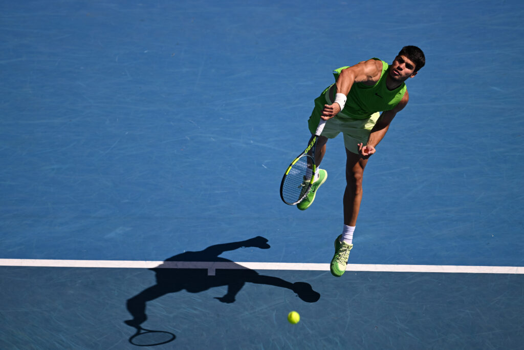 Carlos Alcaraz hits a serve against Tommy Paul at the 2026 Australian Open.