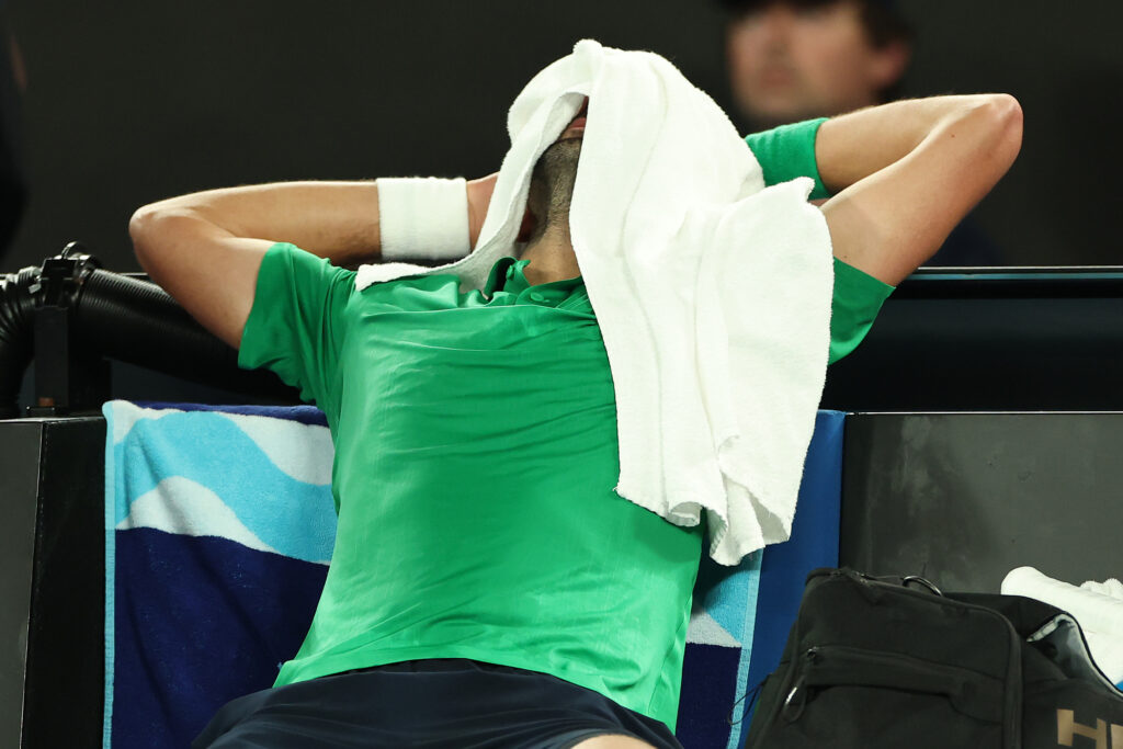 Novak Djokovic puts a towel over his head during his semifinal match against Jannik Sinner at the 2026 Australian Open.