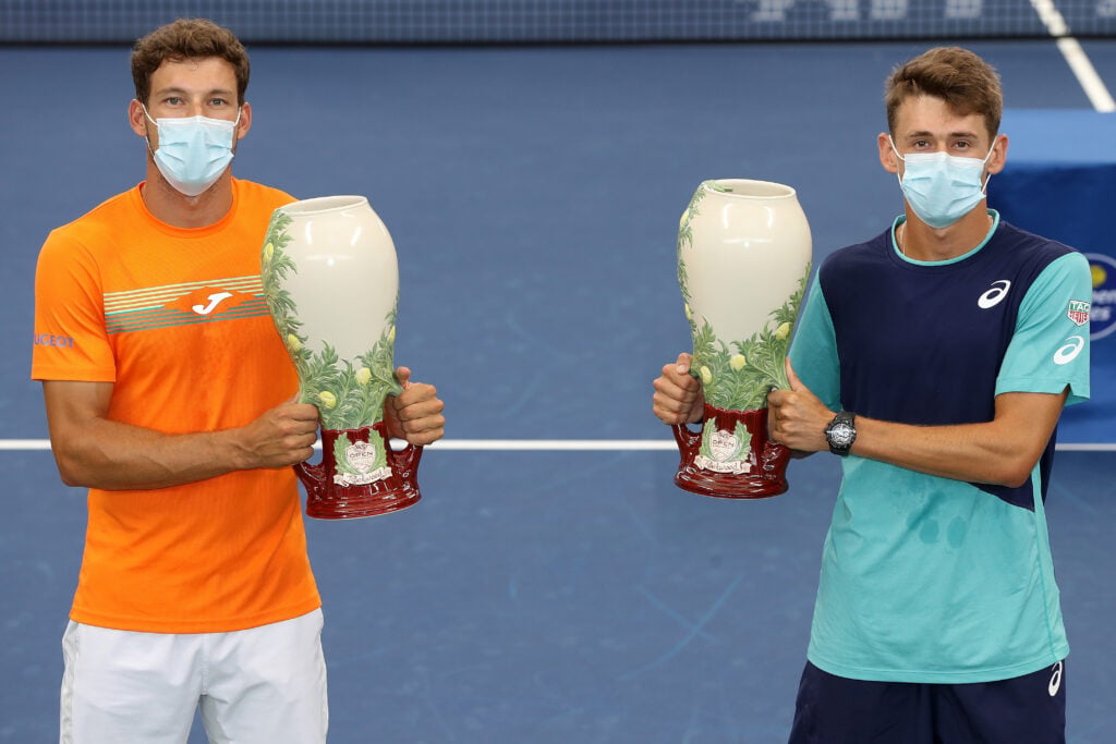 Pablo Carreno Busta and Alex de Minaur holding their trophies after winning the 2020 Cincinnati Open doubles title.