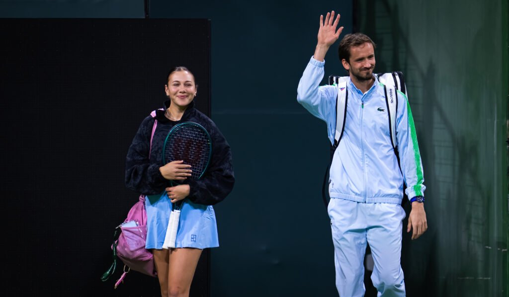 Amanda Anisimova and Daniil Medvedev walk on to court for the 2025 Eisenhower Cup mixed doubles event at Indian Wells.