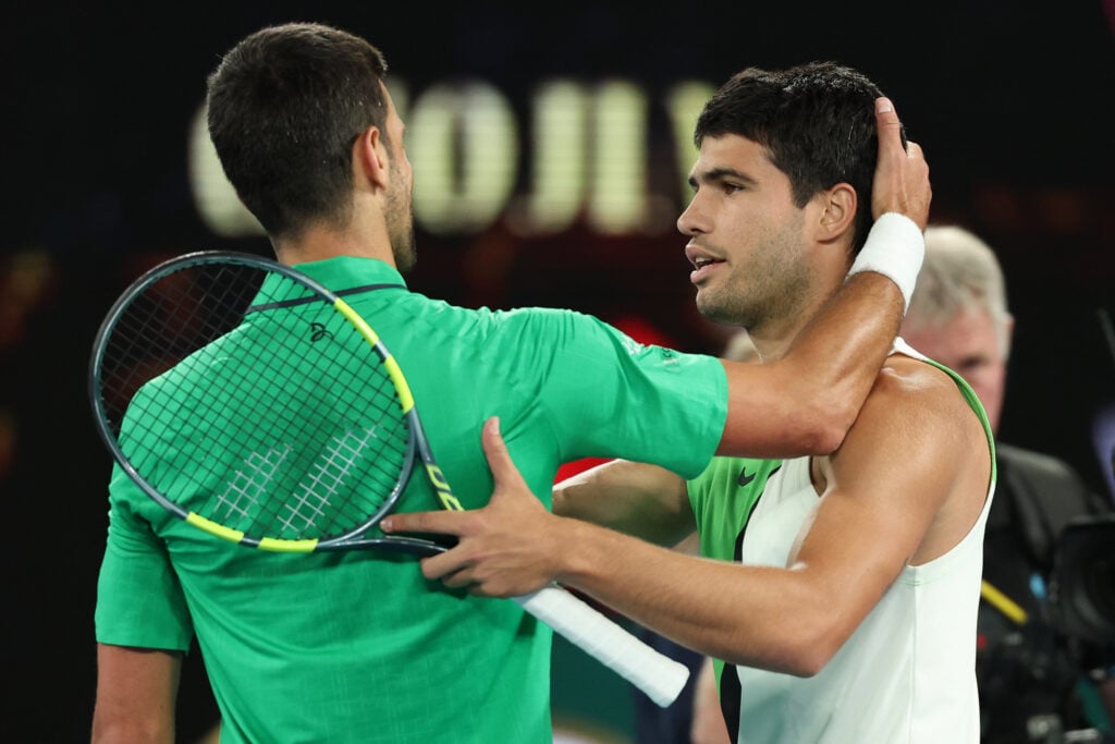 Carlos Alcaraz and Novak Djokovic embrace.