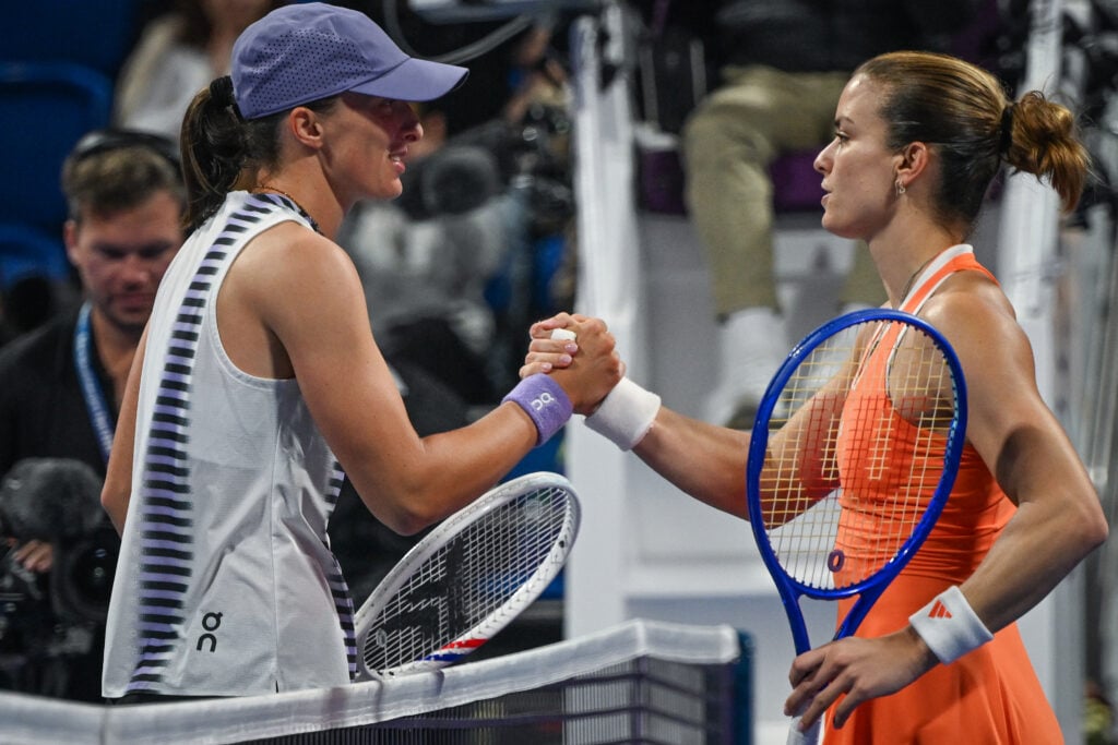Maria Sakkari and Iga Swiatek shake hands at the net