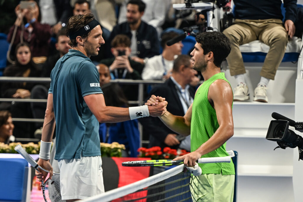 Carlos Alcaraz and Arthur Rinderknech shake hands after their match in Qatar