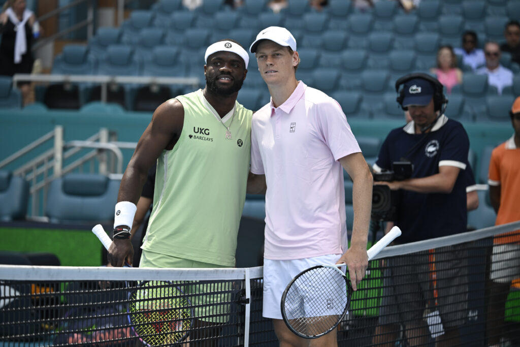 Jannik Sinner and Frances Tiafoe pose at the net