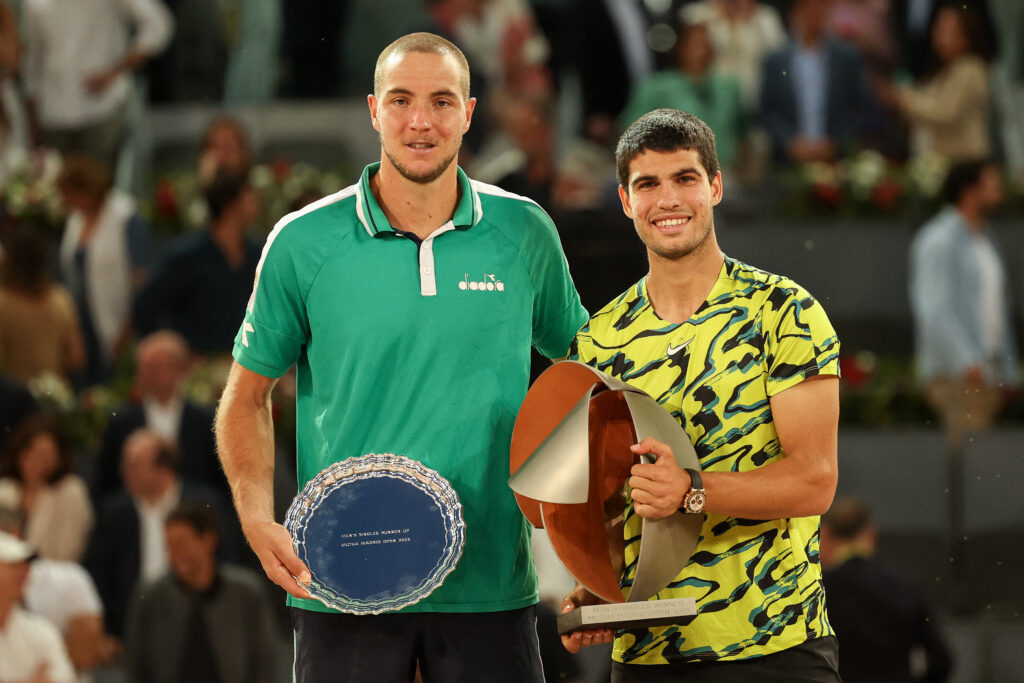 Jan-Lennard Struff and Carlos Alcaraz pose with trophies after the 2023 Madrid Open.