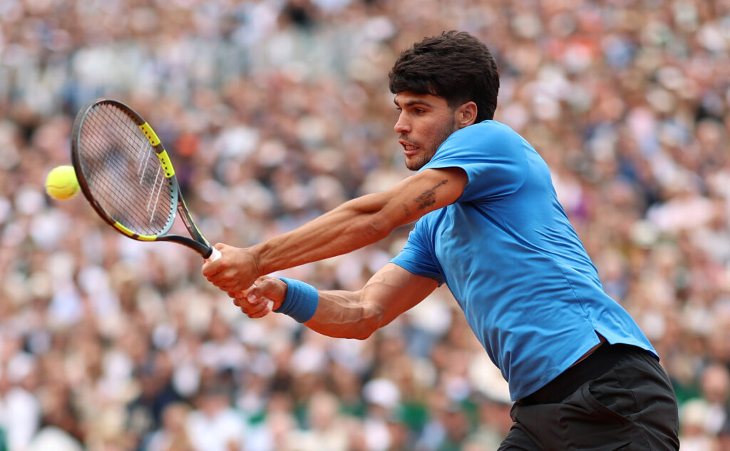 Carlos Alcaraz hits a backhand against Jannik Sinner in the 2026 Monte Carlo Masters final.