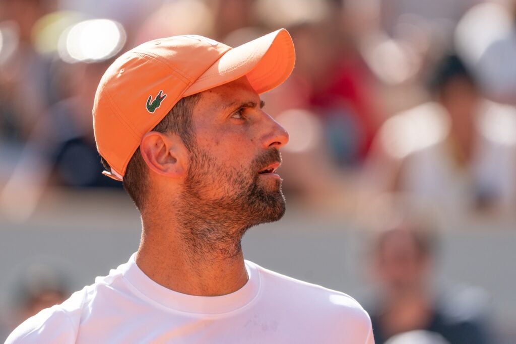 Novak Djokovic looks on.