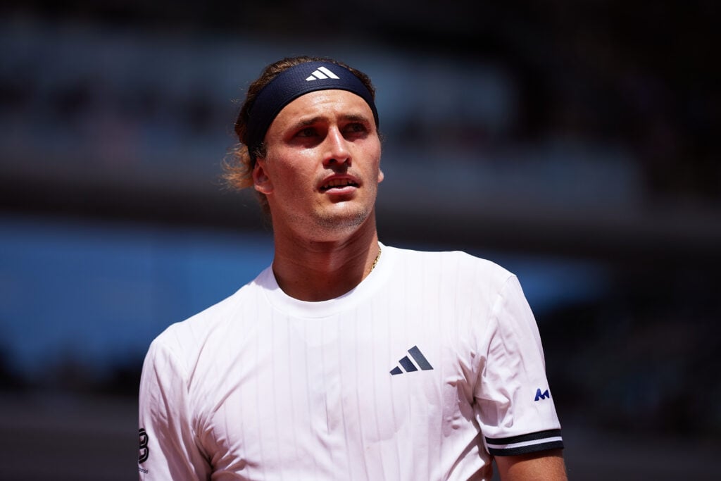 Alexander Zverev looks on.