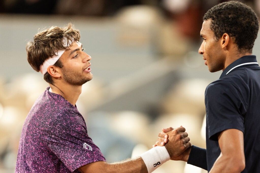 Felix Auger-Aliassime and Flavio Cobolli shake hands at Roland Garros.