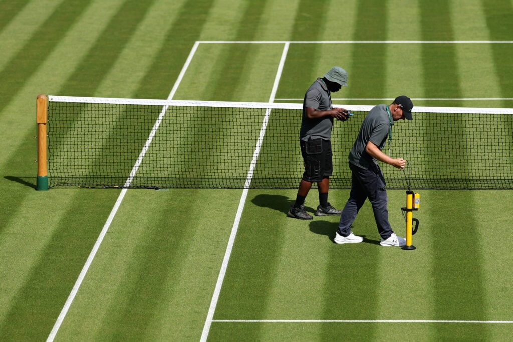 Groundsmen inspect the grass on Centre Court at Wimbledon.