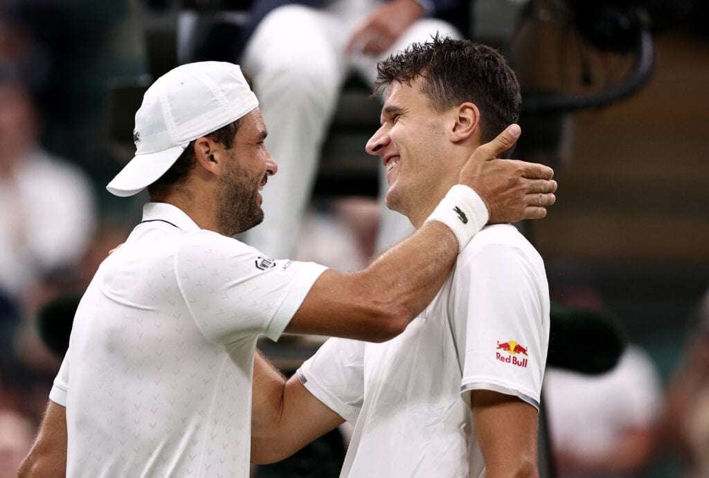Grigor Dimitrov and Jakub Mensik embrace at Wimbledon.