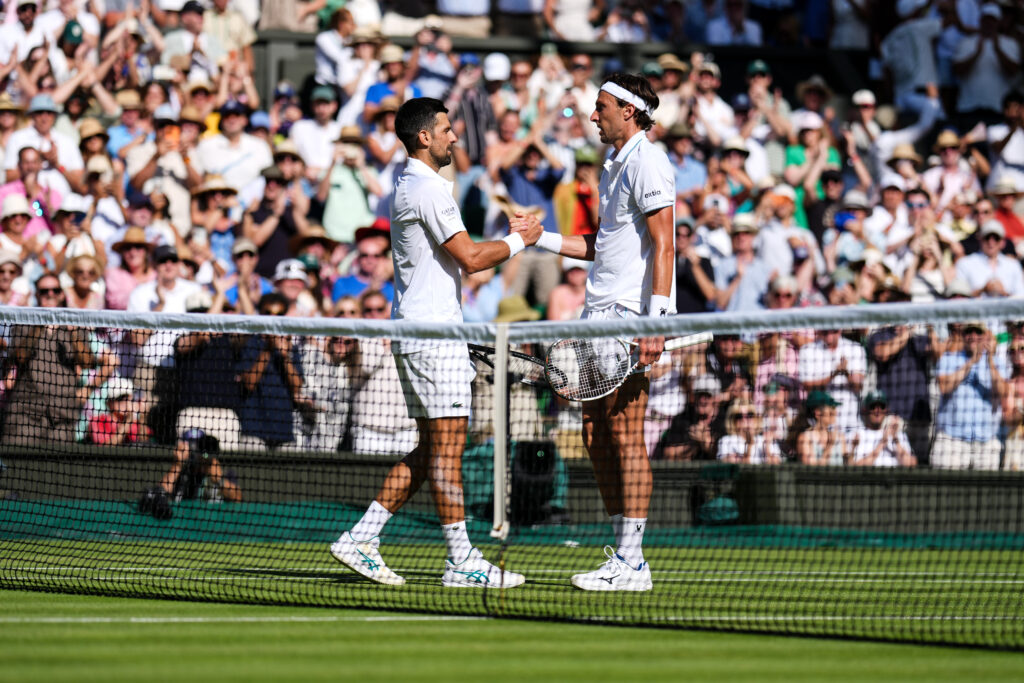Novak Djokovic and Arthur Rinderknech embrace.