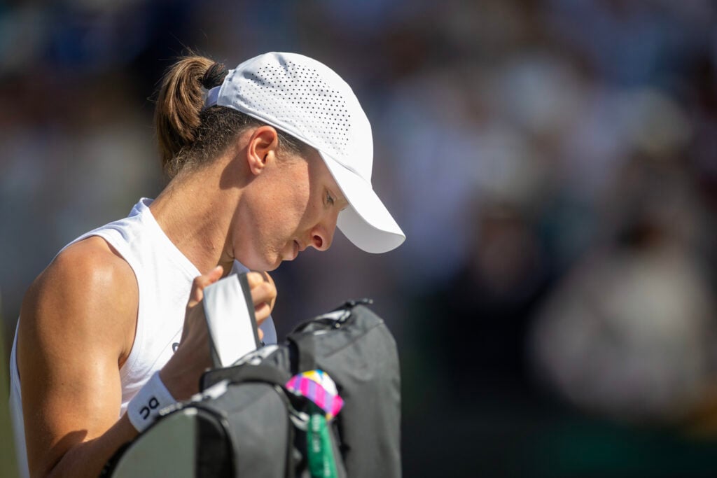 Iga Swiatek prepares to leave the court after her loss at Wimbledon.