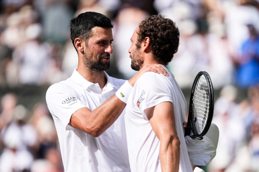 Novak Djokovic and Roman Safiullin embrace.