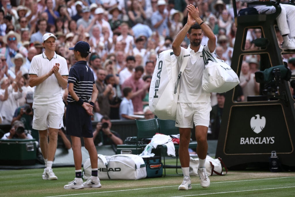 Jannik Sinner claps as Novak Djokovic leaves Centre Court at Wimbledon.